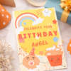 kids birthday invitation with rainbow and cupcake design close up