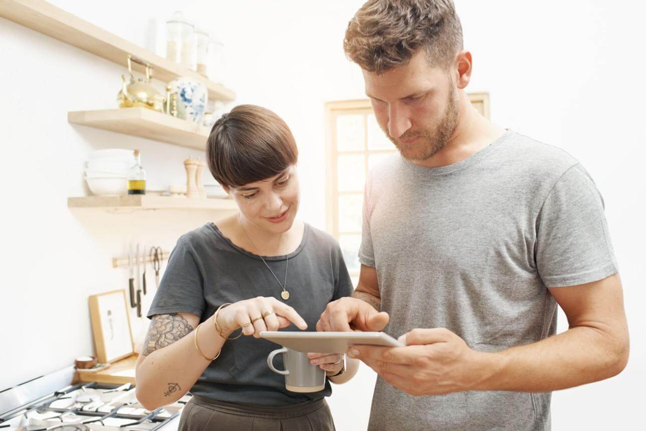 couple sending digital wedding invitations on smartphone